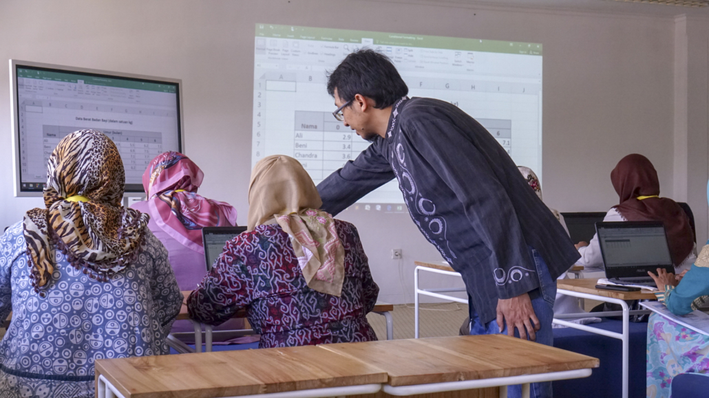 Bapak Dhomas Hatta Fudholi, Ph.D. membimbing ibu-ibu kader posyandu dalam mengelola data dengan Microsoft Excel